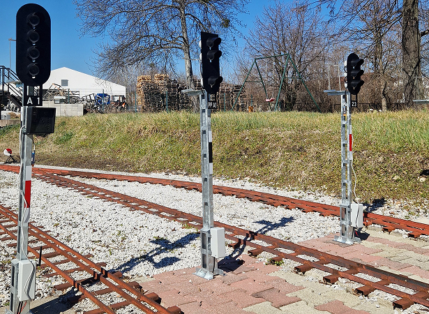 Railroad signals beside train tracks on a sunny day